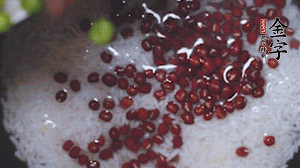 將炒好的食材和大米、紅豆一起放進(jìn)電飯鍋煮。