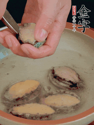 鮑魚加鹽、清水浸泡，用勺子挖出鮑魚肉。