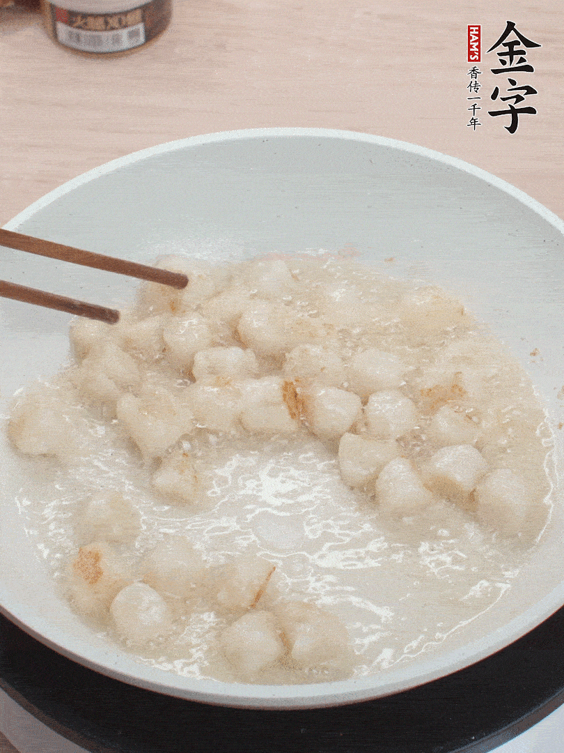 油溫4成熱，鮮貝蘸干淀粉下鍋煎，一面微黃后翻面。