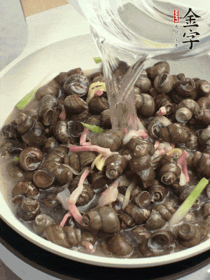 倒處理干凈的螺螄翻炒，加3勺料酒。加清水蓋過螺螄，中火蓋蓋煮5分鐘。